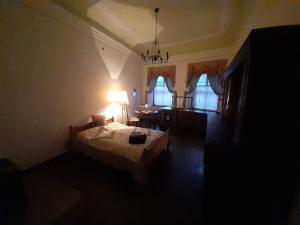 una camera con letto, lampada e finestre di Schloss Ottendorf a Bahretal