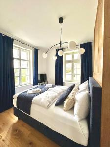 a bedroom with a large bed with blue curtains at betterplaces: Boutique Apartments - Frontenhausen in Dingolfing