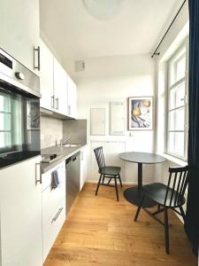 uma cozinha com uma mesa e duas cadeiras e uma mesa em betterplaces Boutique Apartments - Frontenhausen em Dingolfing
