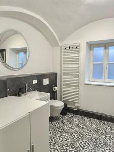 um banheiro com uma pia, um vaso sanitário e um espelho em betterplaces Boutique Apartments - Frontenhausen em Dingolfing