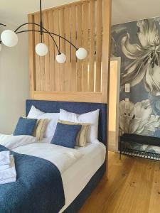 a bedroom with a large bed with blue and white pillows at betterplaces: Boutique Apartments - Frontenhausen in Dingolfing