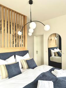 a bedroom with a bed with white sheets and blue pillows at betterplaces: Boutique Apartments - Frontenhausen in Dingolfing