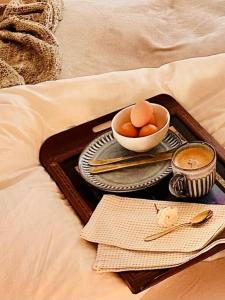 uma bandeja com uma tigela de ovos e uma chávena de café em Snowy Valleys iconic stay - Moonshiner Cottage @ Distillery em Tumbarumba
