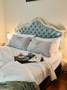 a bed with a blue headboard with a tray on it at Snowy Valleys iconic stay - Moonshiner Cottage @ Distillery in Tumbarumba