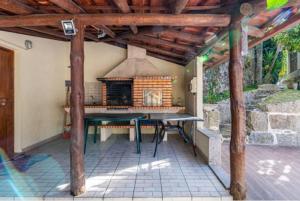 um pátio com uma mesa e uma lareira exterior em Casa do Fijogo - Family friendly Villa with a Private Pool em Rio Caldo