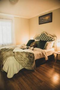 a bedroom with a large bed with a wooden floor at Snowy Valleys iconic stay - Moonshiner Cottage @ Distillery in Tumbarumba