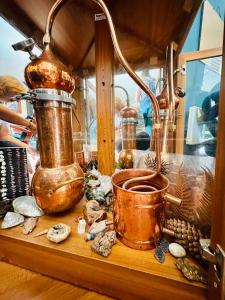 uno scaffale con una pentola e altri oggetti sopra di Snowy Valleys iconic stay - Moonshiner Cottage @ Distillery a Tumbarumba