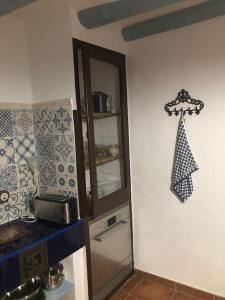 a kitchen with a sink and a cabinet with a clock on the wall at Ca la Trini - turisme rural in Torrellas de Foix
