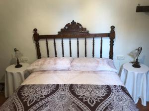 1 cama con cabecero de madera y 2 mesas en Ca la Trini - turisme rural, en Torrelles de Foix