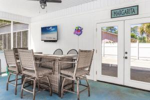 a porch with a table and chairs and a tv at Southern Charm in Foley