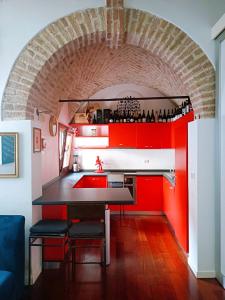 eine Küche mit roten Schränken und einer Ziegelwand in der Unterkunft Wine house in Padua