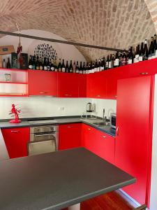 eine rote Küche mit einem Waschbecken und einer Theke mit Weinflaschen in der Unterkunft Wine house in Padua