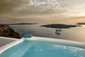 a swimming pool with a view of the ocean at Kamares Apartments in Fira