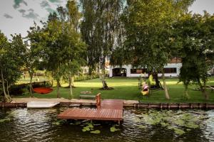 een picknicktafel op het water in een park bij Art&Lake House in Pasym
