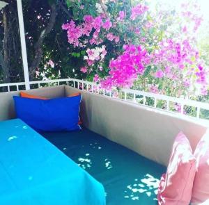 a bench sitting on a balcony with pink flowers at Aydın Pansiyon in Ortaca