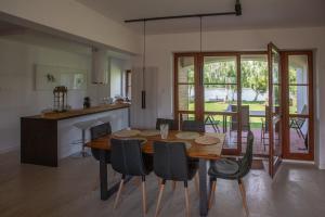 uma cozinha e sala de jantar com uma mesa de madeira e cadeiras em Art&Lake House em Pasym