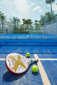 uma raquete de ténis e uma bola num campo de ténis em Le Sultan em Hammamet