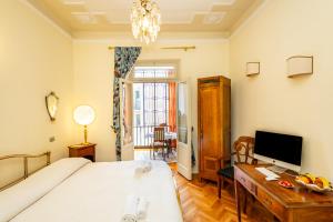 ヴェローナにあるArt Déco - locazione turisticaのベッドルーム1室(ベッド1台、デスク、テレビ付)