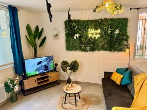 uma sala de estar com um sofá e uma televisão em Évasion Jungle em Narbona