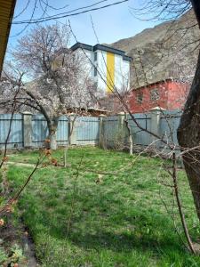 a yard with a fence and a house at A cosy House with a wonderful Garden in Khorog