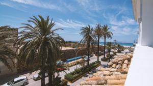 uma vista para uma rua com palmeiras e o oceano em Alquiler Turístico Avenida Playa em Zahara de los Atunes