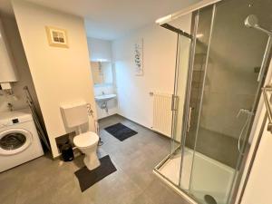 a bathroom with a toilet and a glass shower at Leoben City Apartments - Premium Apartments 24 7 in Leoben