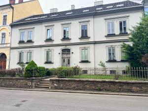 a white house on the side of a street at Leoben City Apartments - Premium Apartments 24 7 in Leoben