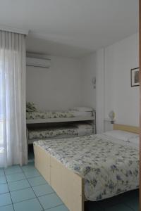 1 dormitorio con 2 camas y ventana en Residence Ambra, en Riva del Garda