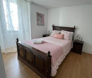 Un dormitorio con una cama grande con sábanas y almohadas rosas. en Vouga Lodge, en São Pedro do Sul