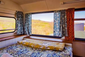 ein Schlafzimmer mit einem Bett und einem Fenster auf einem Zug in der Unterkunft Double decker bus at Valentia Island Escape in Valentia Island