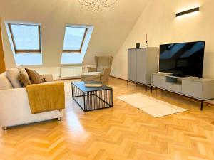 sala de estar con TV de pantalla plana y sofá en Leoben City Apartments - Premium Apartments 24 7, en Leoben