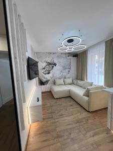 a living room with a white couch and a television at Zeus Ultra Apartament in Baia Mare