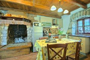 eine Küche mit einem Tisch und einem Steinkamin in der Unterkunft Beautiful stone Villa with private pool near Rabac in Barbići
