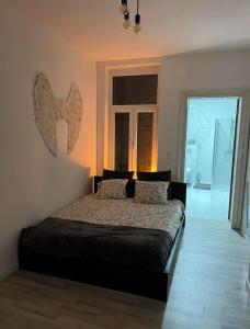 een slaapkamer met een bed met 2 kussens erop bij Romeo et juliette in Spa
