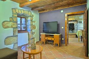ein Wohnzimmer mit einem TV und einem Tisch in der Unterkunft Beautiful stone Villa with private pool near Rabac in Barbići