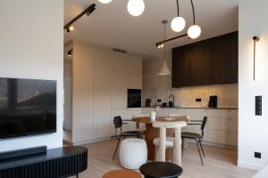 a kitchen and dining room with a table and a tv at Apartament Olchowa in Ustroń