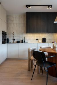 a kitchen with white cabinets and a table at Apartament Olchowa in Ustroń