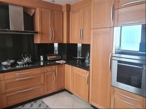 a kitchen with wooden cabinets and black counter tops at Agadir, Simple mais confortable in Agadir