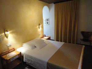 sypialnia z dużym białym łóżkiem i krzesłem w obiekcie Ristorante Stazione w mieście Tesserete