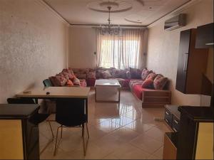 a living room with a couch and a table at Agadir, Simple mais confortable in Agadir +4 photos