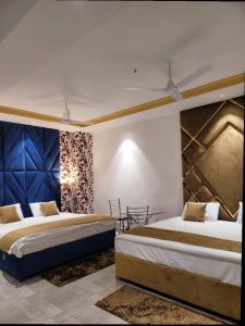 a hotel room with two beds and a table at Bellazio Suites Hotel & Resort in Bareilly