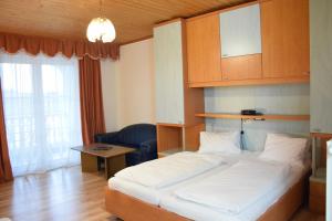 ein Hotelzimmer mit einem Bett und einem Stuhl in der Unterkunft Appartmenthaus Rosenhof in Podersdorf am See