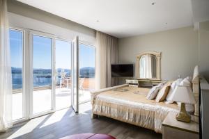 a bedroom with a large bed and a balcony at Villa Monte Leone by Konnect with Pool, Hot Tub, Spa Room & Stunning Seaview in Pyrgi