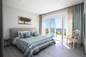 a bedroom with a bed and a view of the ocean at Villa Monte Leone by Konnect with Pool, Hot Tub, Spa Room & Stunning Seaview in Pyrgi