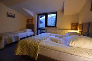 sypialnia z 2 łóżkami i oknem w obiekcie Sasanka Szczyrk przy Gondoli w Szczyrku