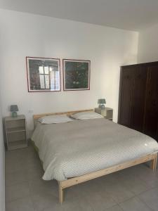 um quarto com uma cama e duas fotografias na parede em Giuditta B&B stanza em Ciriè