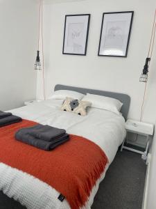 The Cowpen & Garage في Bebside: غرفة نوم بسرير وبطانية حمراء وبيضاء