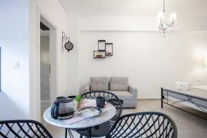 a living room with a table and chairs and a couch at Hephaestus Luxury flat Psyrri square in Athens