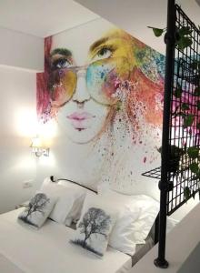 a large painting of a woman with glasses on a wall at Hephaestus Luxury flat Psyrri square in Athens