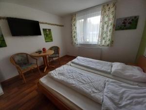 een slaapkamer met een bed, een tafel en een televisie bij Feriencamp Trassenheide in Trassenheide